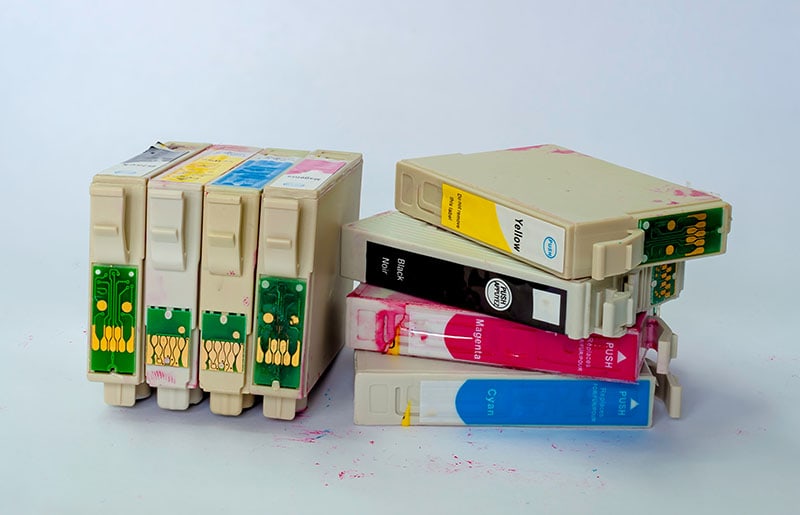 A jumbled stack of empty ink-jet printer cartridges
