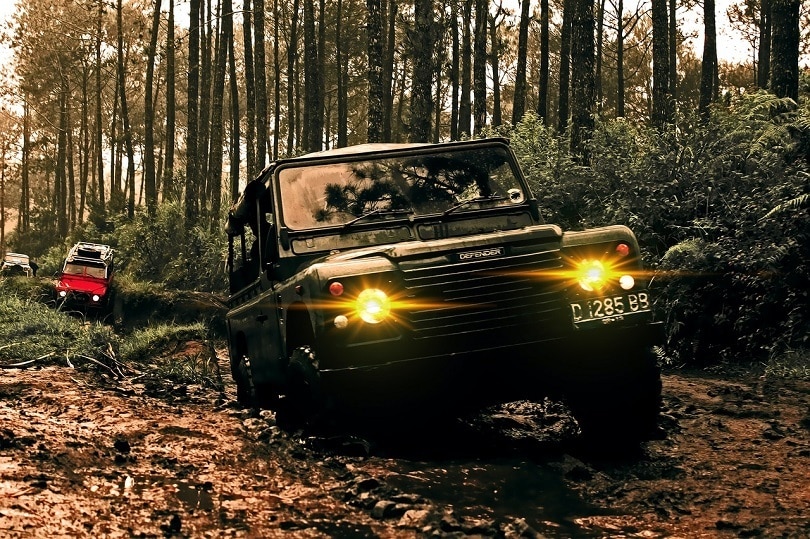 Black suv driving through mud
