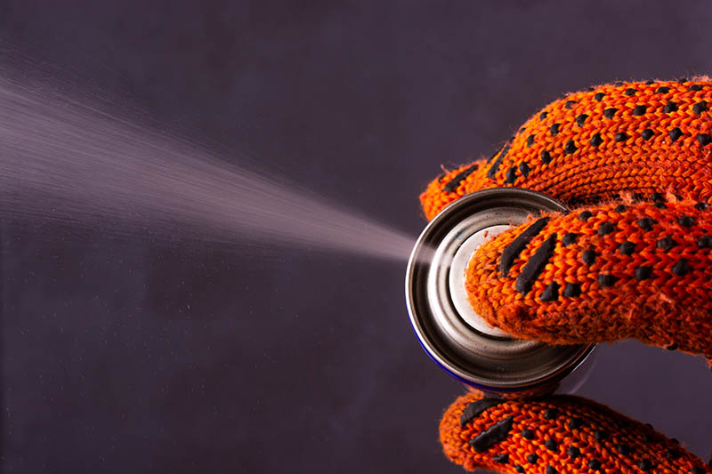 close up hand spraying WD-40