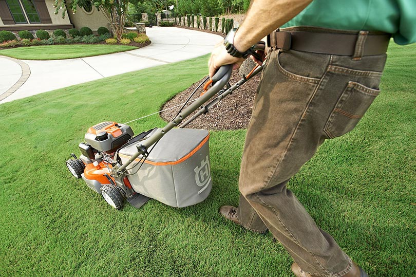 cropped man mowing lawn with lawn mower