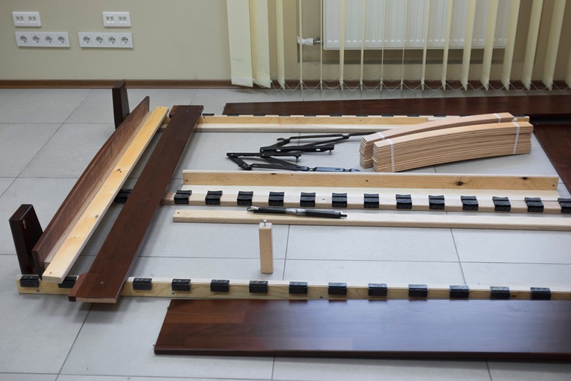disassembled wooden bed on the floor