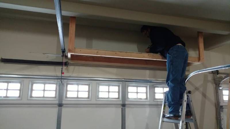 DIY over garage door hidden shelving