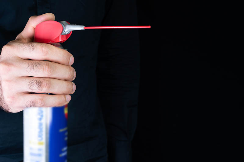 hand holding a can of WD-40