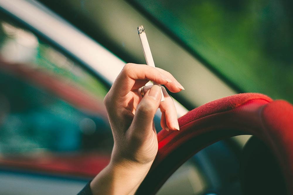 hand holding a cigarette inside the car