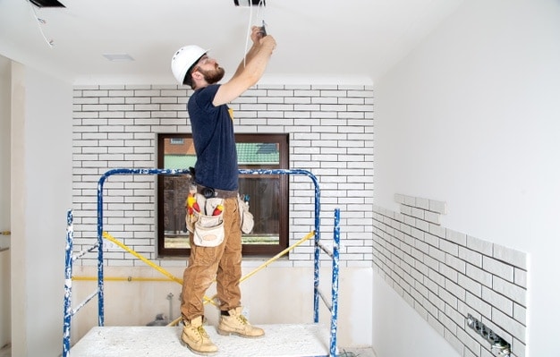 handyman working on light fixtures