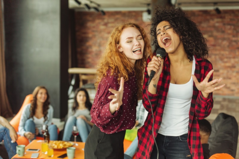 Happy friends having karaoke