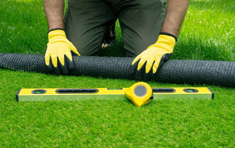 holding rolled artificial grass