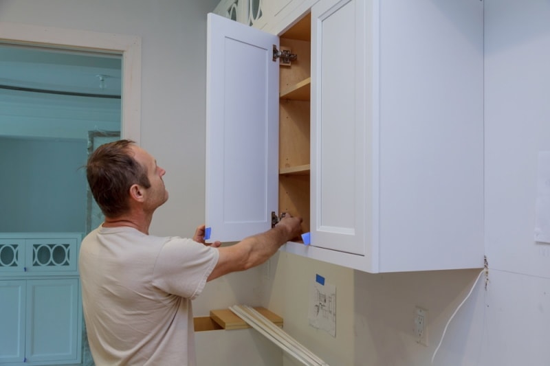 man checking cabinet door