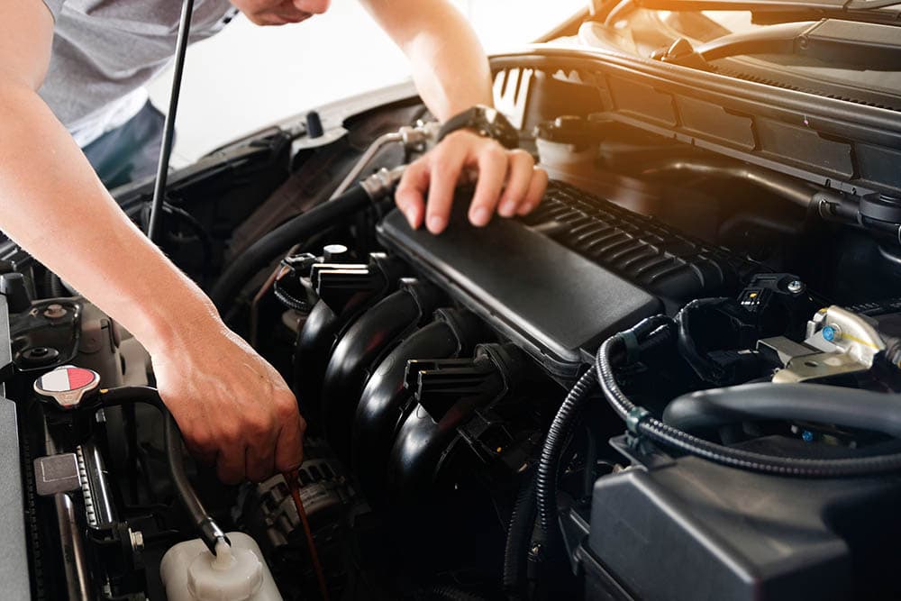 man checking car engine