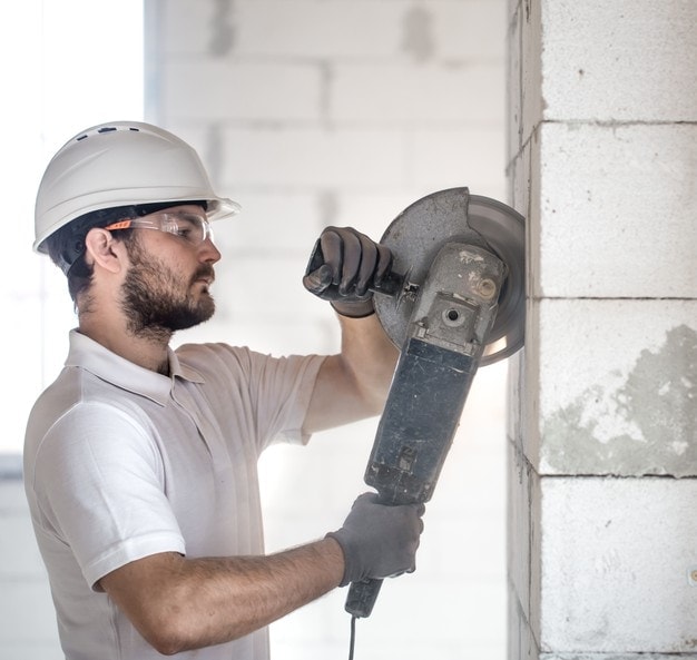 man cutting bricks with angle grinder