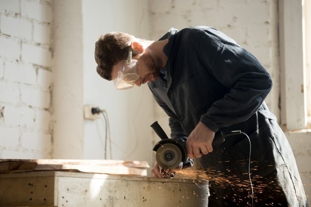 man cutting metal with angle grinder