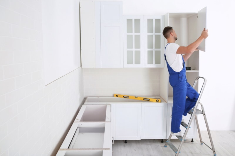 man installing cabinet door