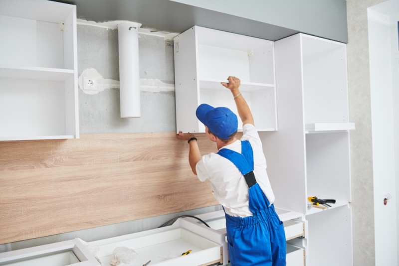 man installing kitchen cabinet