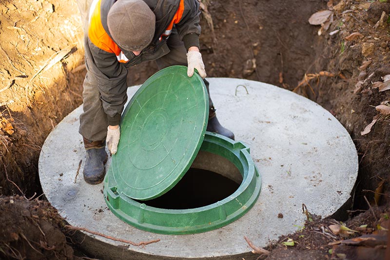 man opening a septic tank