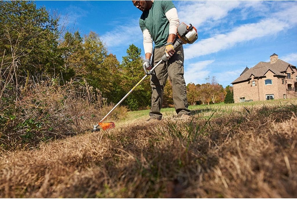 man using Husqvarna 324L Cutting Path Gas String Trimmer