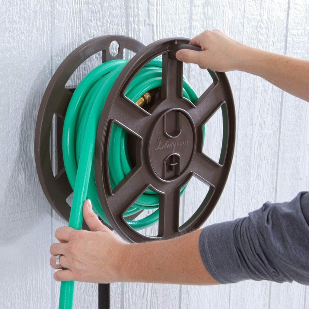 person holding Liberty Garden 510 Wall Mount Hose Reel