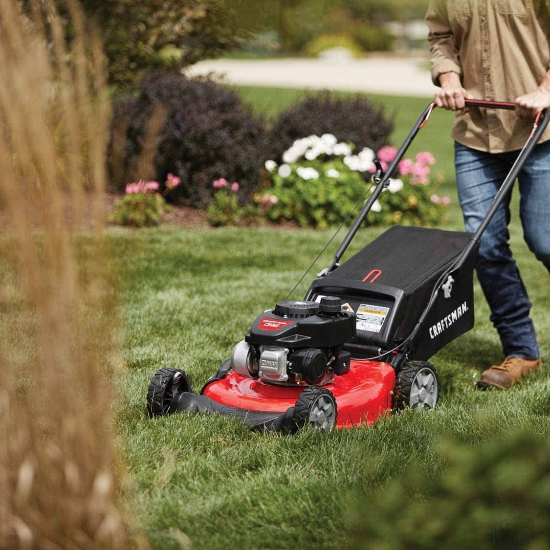 person using Craftsman M105 140cc 21-Inch 3-in-1 Gas Powered Push Lawn Mower with Bagger