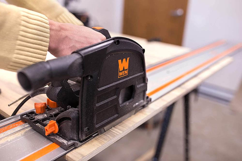 person using WEN CT1065 10-Amp 6.5-Inch Plunge Cut Sidewinder Circular Track Saw
