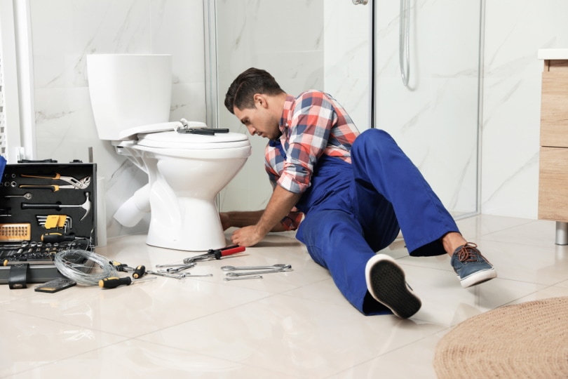 plumber working with toilet leak