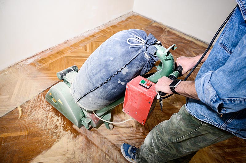 Sanding hardwood floor with the grinding machine