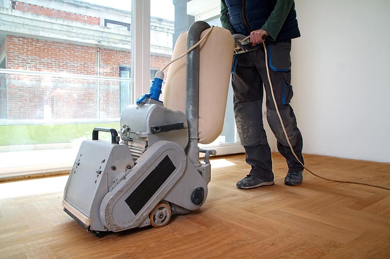 Sanding hardwood floor with the grinding machine