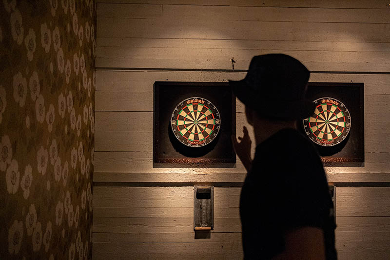 silhouette of a person playing darts