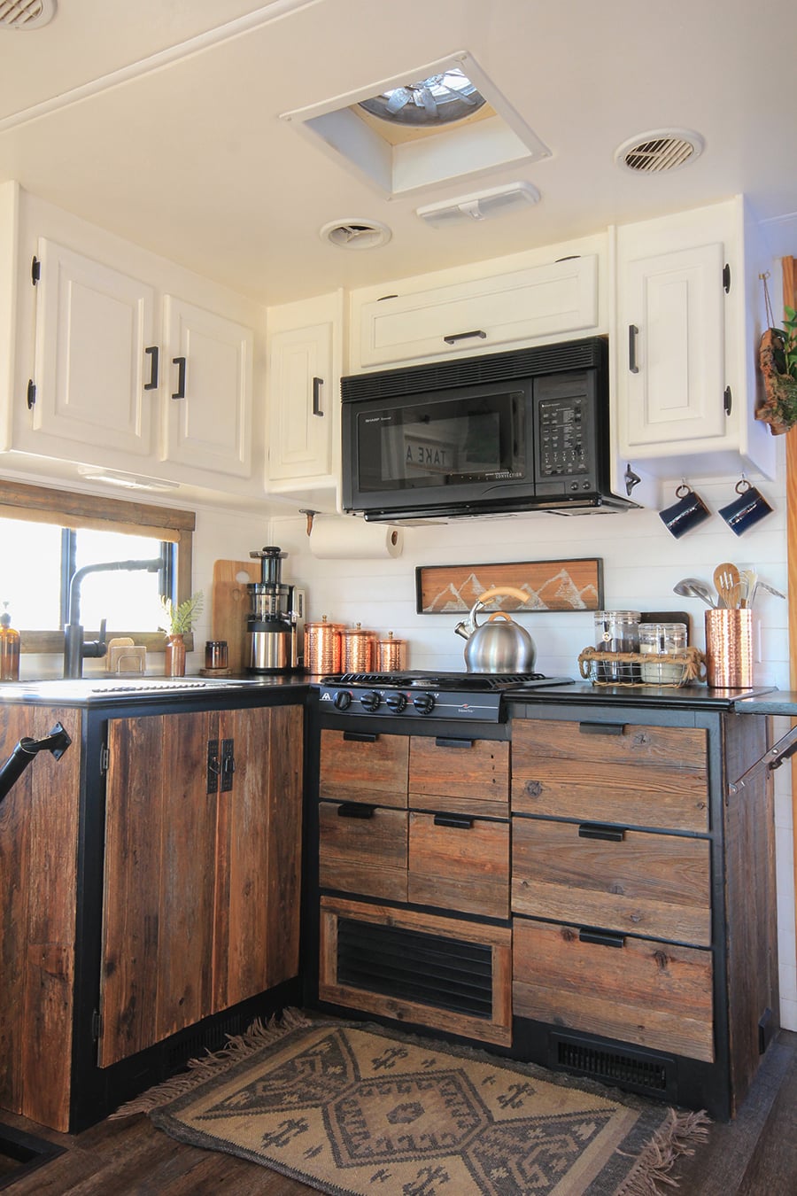 small kitchen with reclaimed cabinets inside rv
