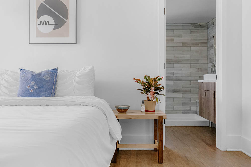 white bedroom with abstract framed wall art