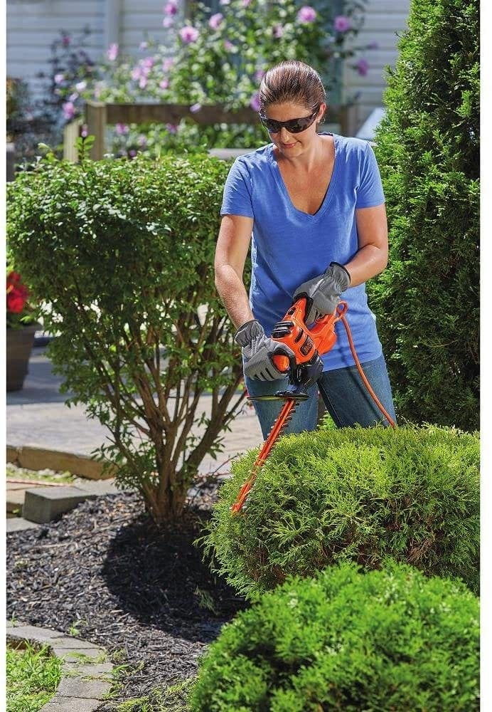 woman using BLACK+DECKER BEHT100 Hedge Trimmer