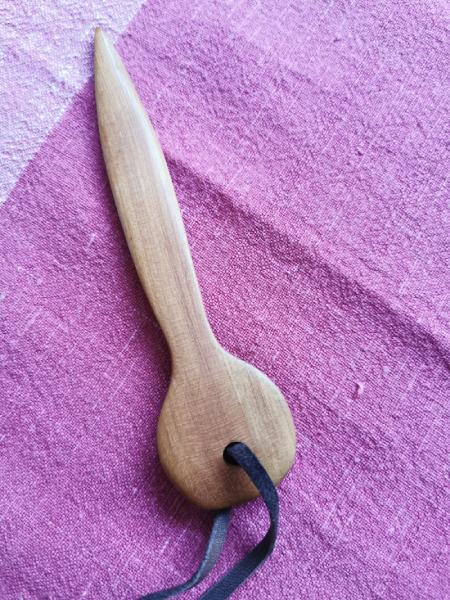wooden letter opener on a purple tablecloth