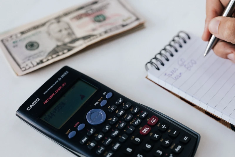person calculating and writing down finances