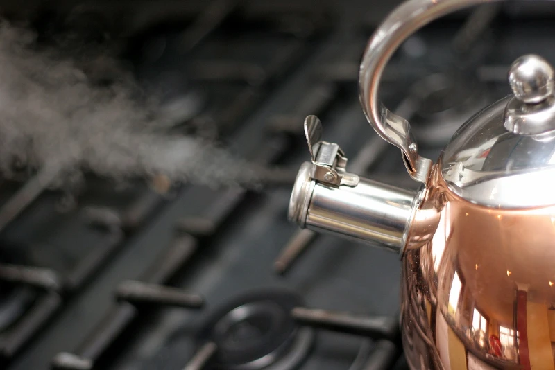 steam coming out of copper kettle from boiling water
